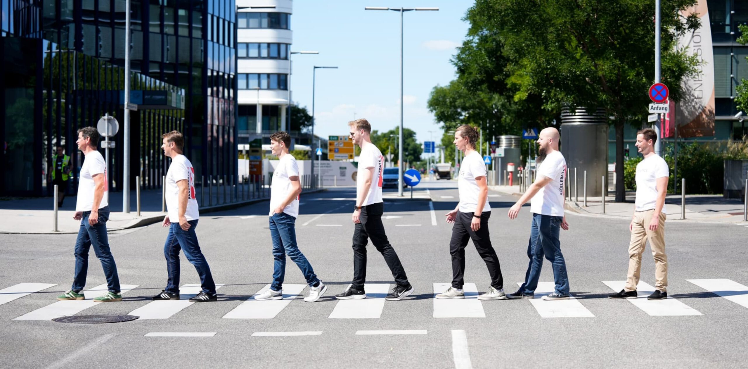 Group of people wearing R-Space T-shirts outdoors, with one shirt prominently showing a CubeSat satellite illustration and the text ‘We Accelerate.